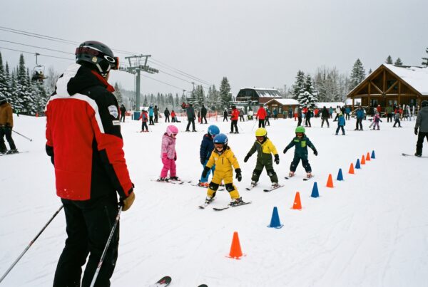 Un moniteur observe plusieurs enfants qui descendent une pente douce balisée sur le front de neige.